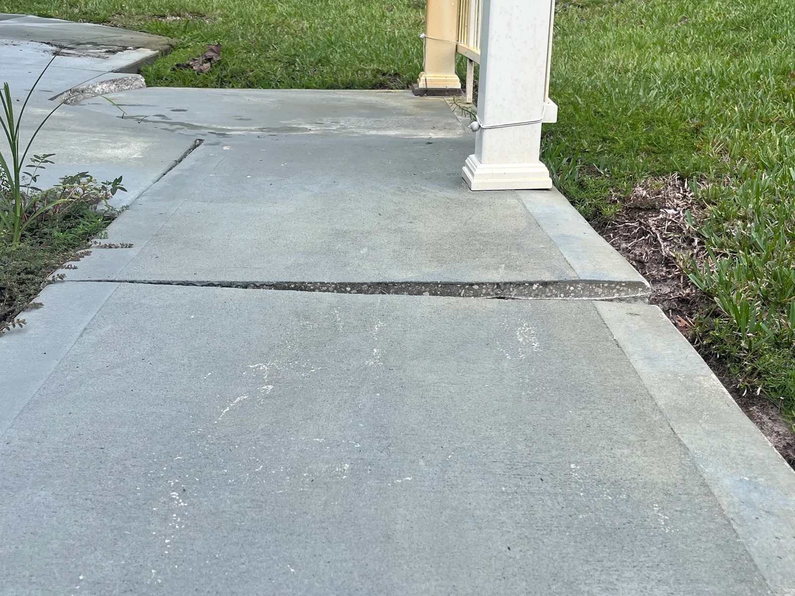 Settled concrete walkway with uneven slabs in Central Florida