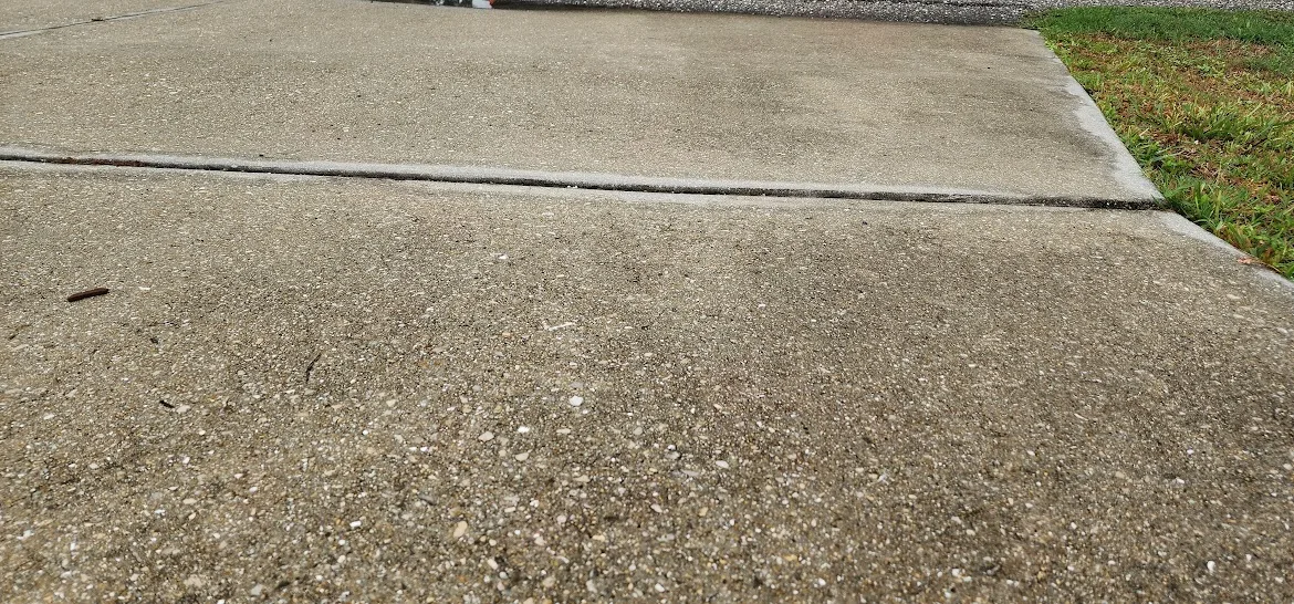 Uneven concrete driveway with settled slab creating a trip hazard in Brooksville FL