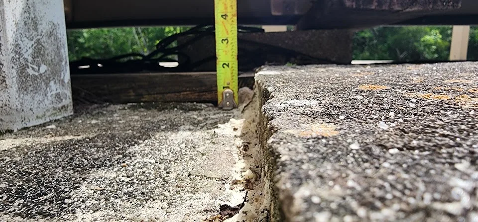 Settled pool deck concrete showing elevation difference before polyurethane lifting