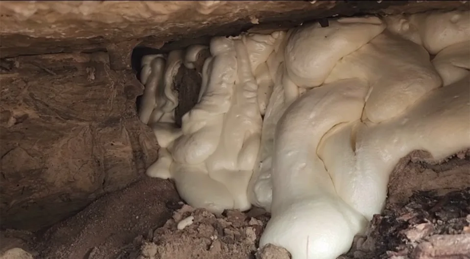 Expanded polyurethane foam filling a void beneath an existing concrete slab