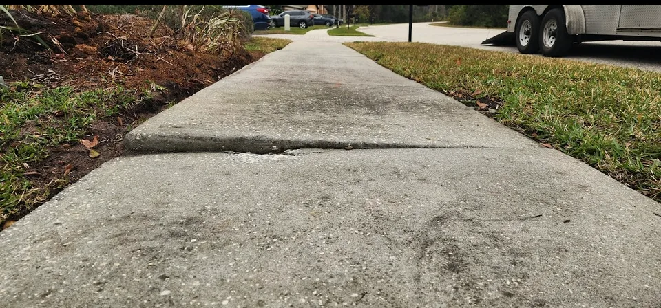 Uneven concrete sidewalk creating a trip hazard before leveling