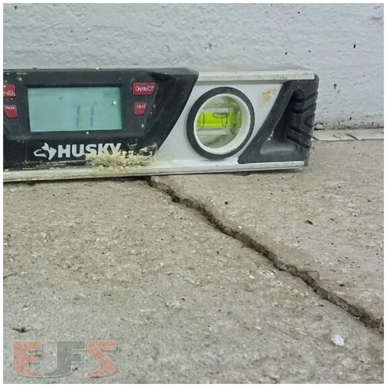 Uneven concrete in Clermont, Florida being checked with a level before polyurethane concrete lifting and leveling